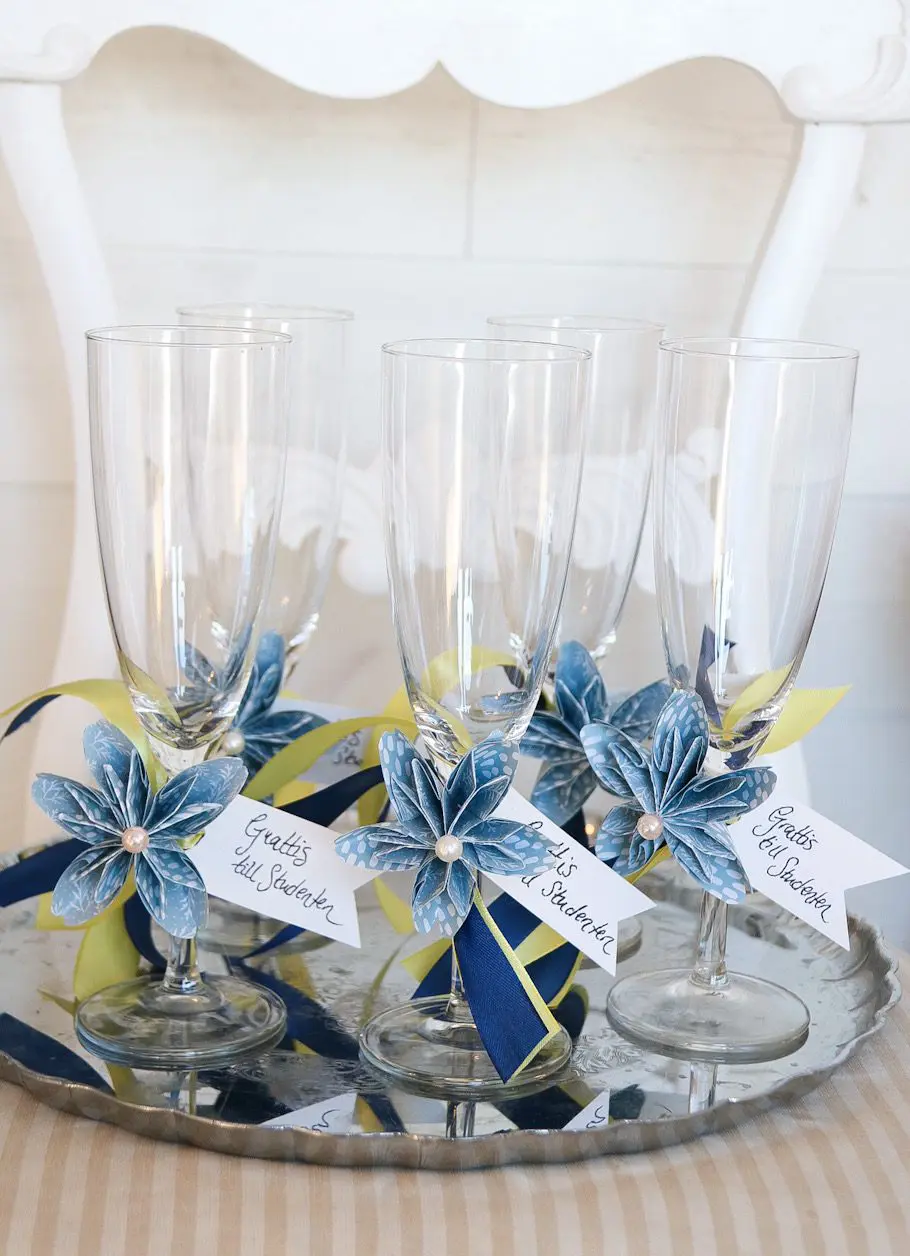 Glas med pappersblomma på silverbricka