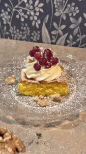 Saftig saffranskaka med färskostfrosting och sockerlingon på glasassiett – juligt recept.