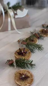 Närbild på torkade apelsinskivor trädda på jutesnöre.