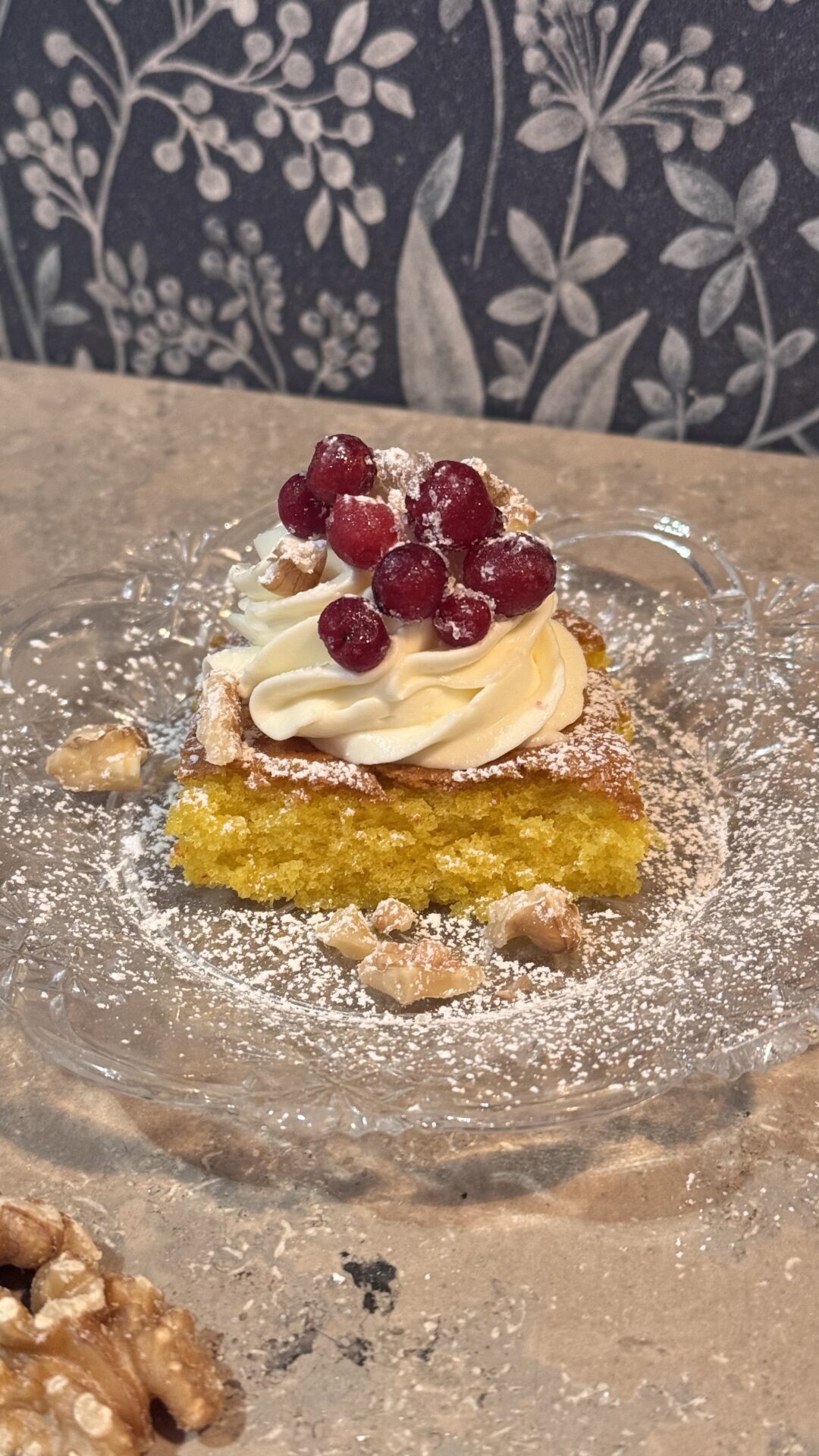 Saftig saffranskaka med färskostfrosting och sockerlingon på glasassiett – juligt recept.